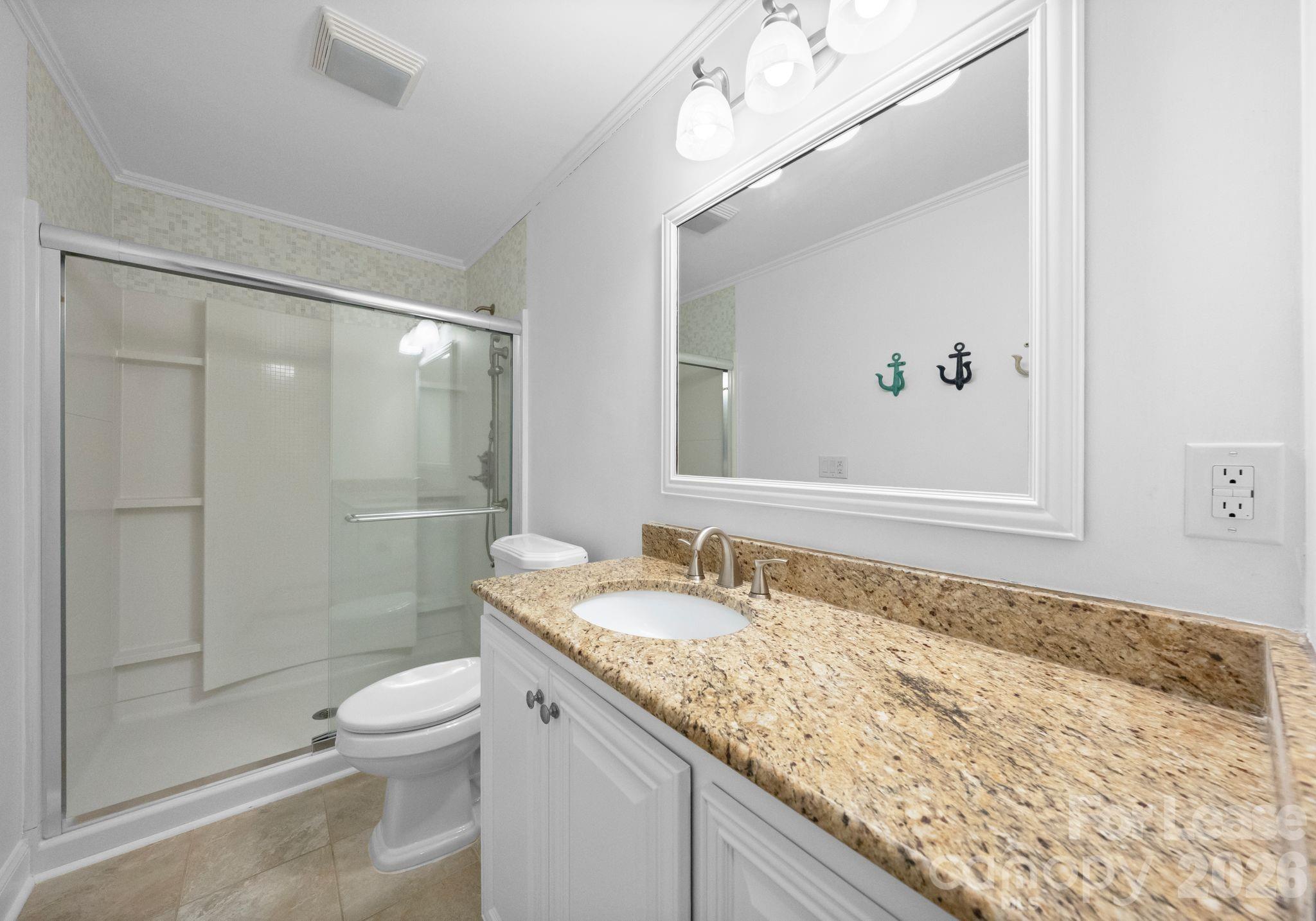 19709 Stough Farm Road Cornelius, NC 28031 - Photo 23 of 48 a bathroom with a granite countertop sink a toilet a mirror and shower