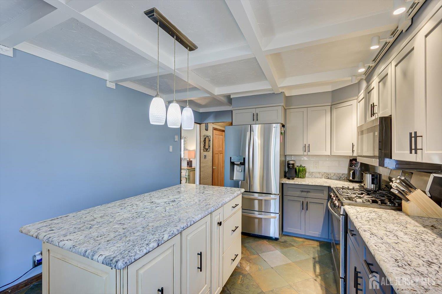 110 Normandy Road Colonia, NJ 07067 - Photo 17 of 57 a kitchen with granite countertop kitchen island stainless steel appliances a sink stove and refrigerator
