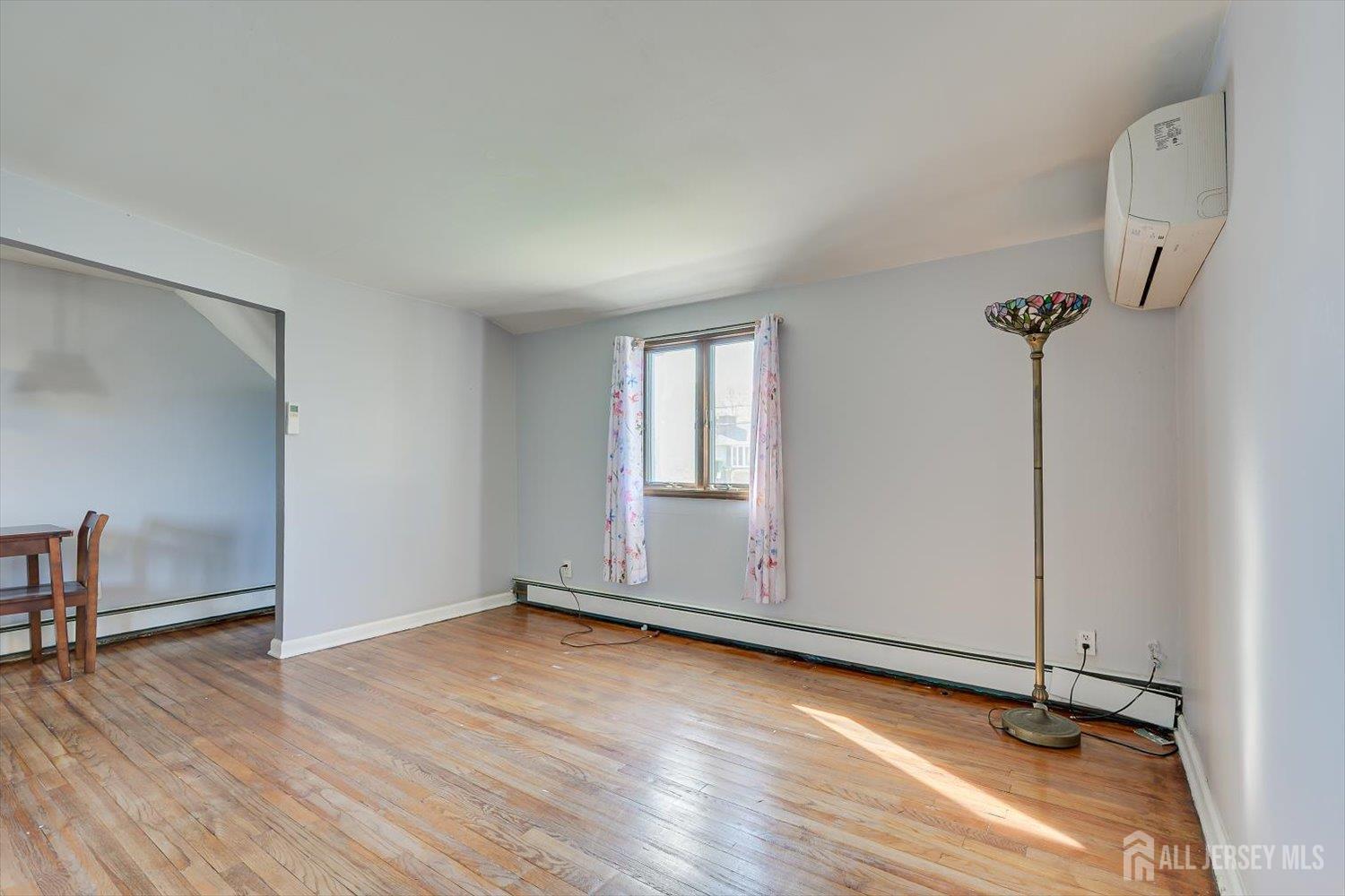 110 Normandy Road Colonia, NJ 07067 - Photo 29 of 57 an empty room with wooden floor and windows