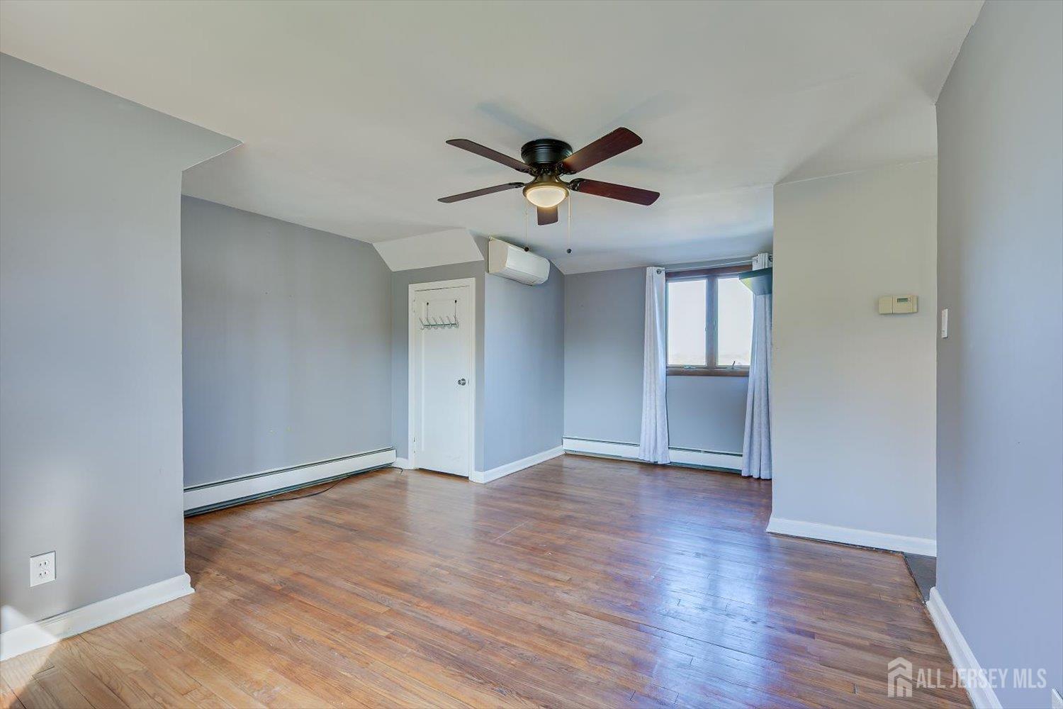 110 Normandy Road Colonia, NJ 07067 - Photo 36 of 57 a view of an empty room with window and wooden floor