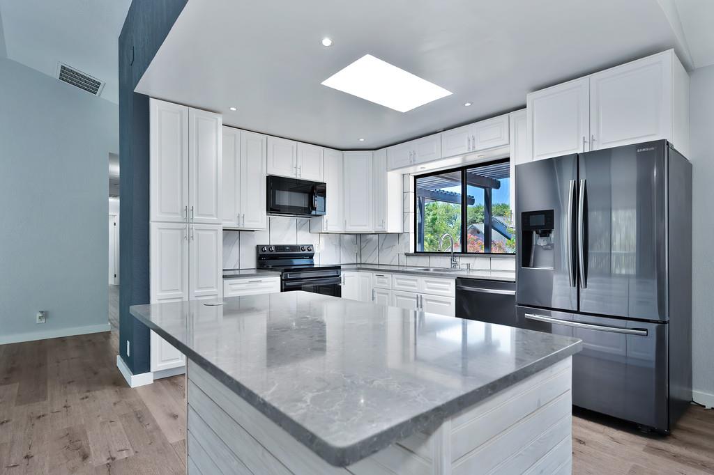 2071 Bogus Point Court Cool, CA 95614 - Photo 21 of 69 a kitchen with kitchen island a large counter top space appliances and cabinets