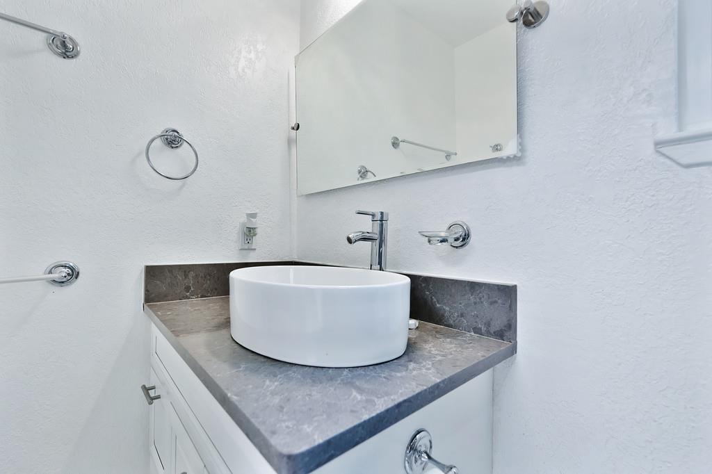 2071 Bogus Point Court Cool, CA 95614 - Photo 42 of 69 a bathroom with a granite countertop sink a mirror and vanity