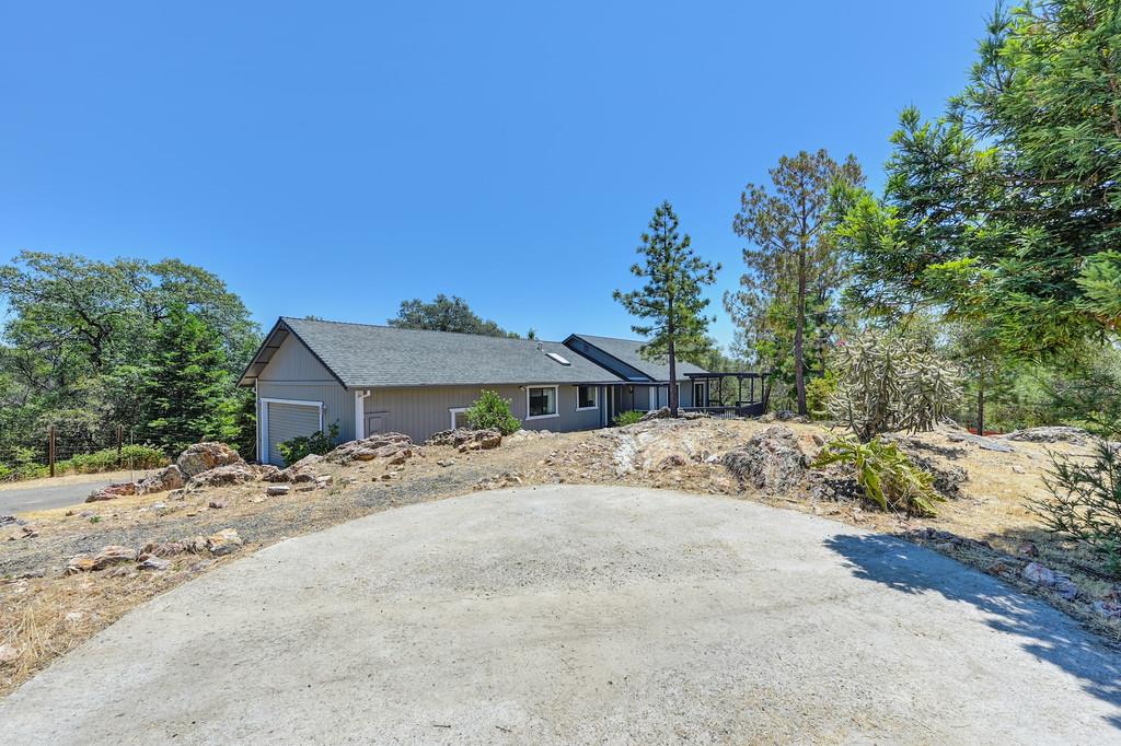2071 Bogus Point Court Cool, CA 95614 - Photo 6 of 69 a view of a house with a dirt yard and a large tree