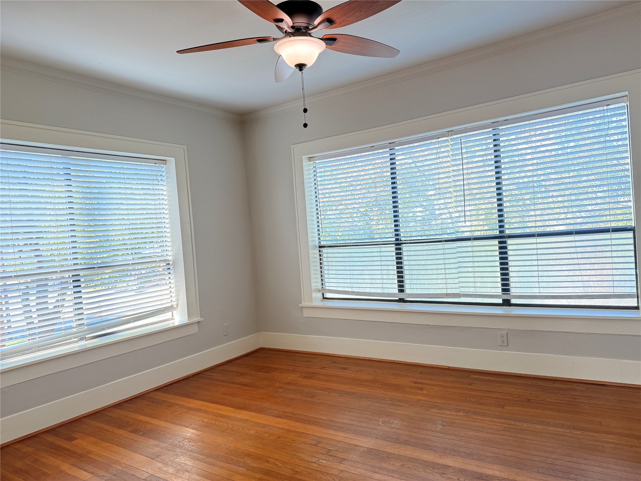 1201 West Gray Street, Unit 3 Houston, TX 77019 - Photo 2 of 14 an empty room with wooden floor fan and windows