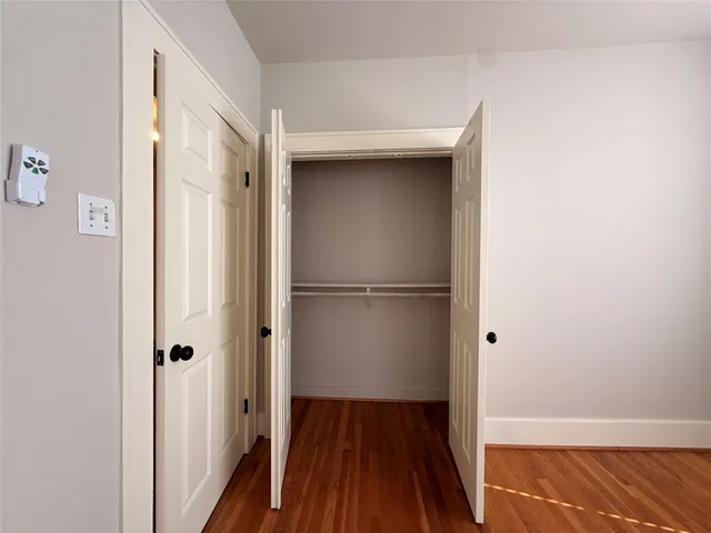 a view of a room with wooden floor and a hallway