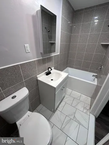 a white toilet sitting next to a bathroom sink