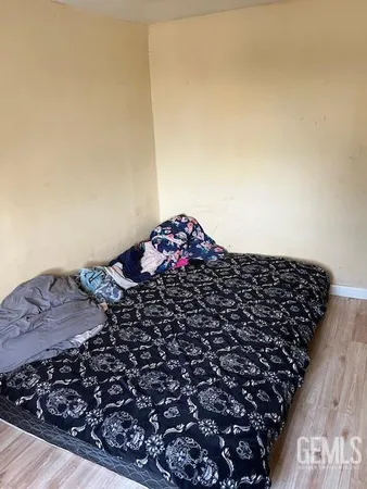 wooden floor with a black and white comforter
