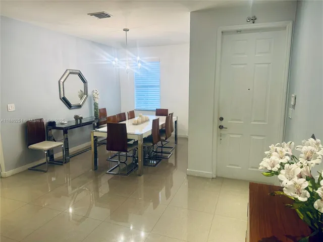 a dining room with furniture a chandelier and a window