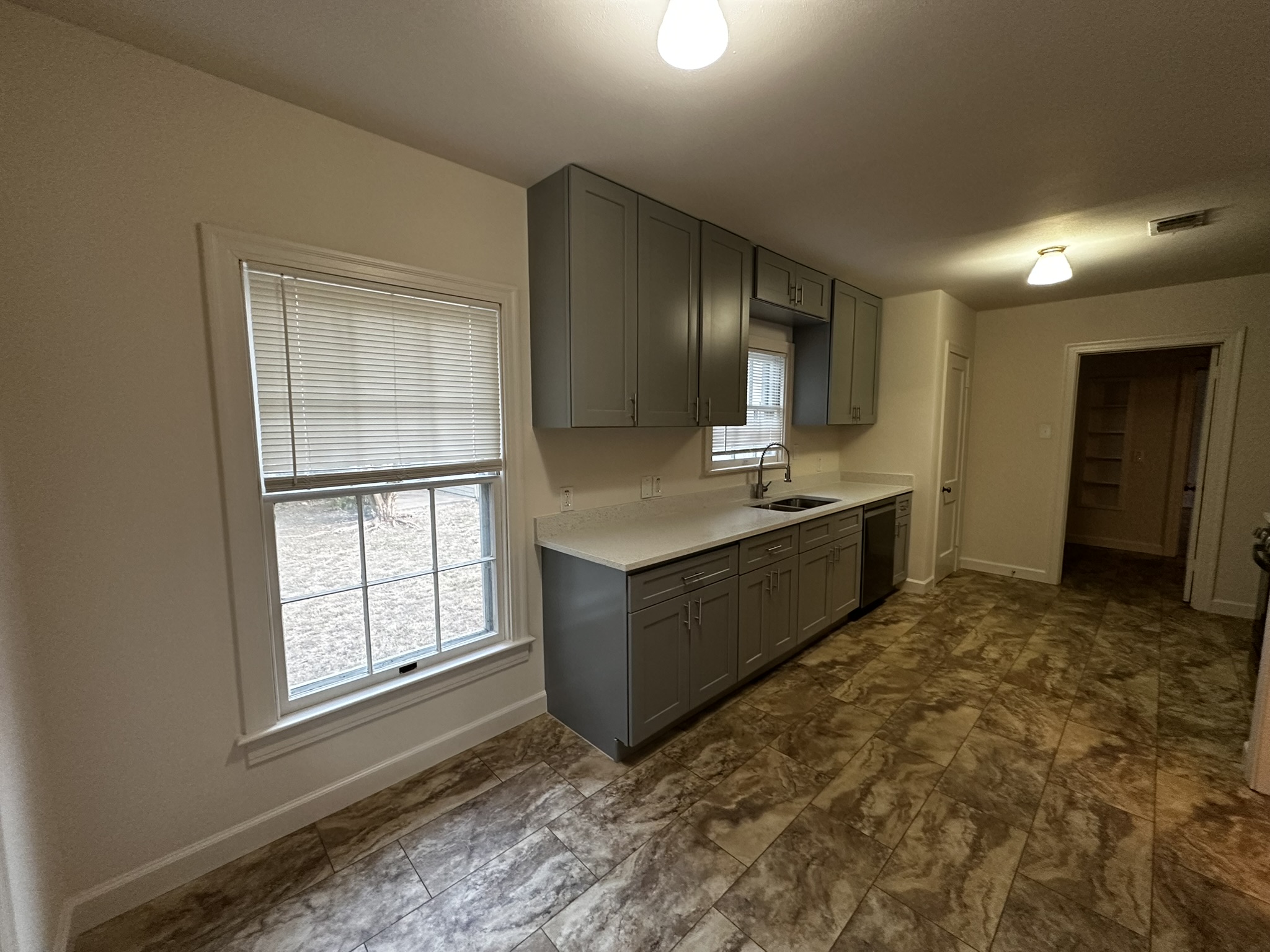 3903 Ridgelea Drive Austin, TX 78731 - Photo 8 of 17 Richly patterned tile flooring stretches across a kitchen space flanked by classic multi-pane windows.