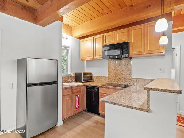 a kitchen with stainless steel appliances granite countertop a refrigerator a stove top oven a sink and dishwasher