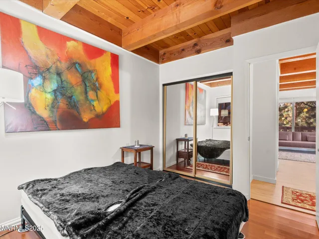 a bedroom with a bed and a dresser next to a window