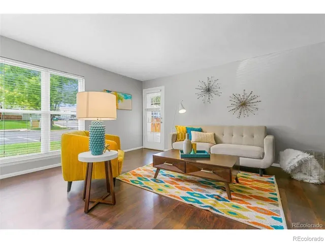 a living room with furniture and a table with wooden floor