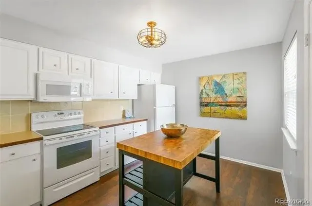 a kitchen with stainless steel appliances a stove a refrigerator and a white cabinets