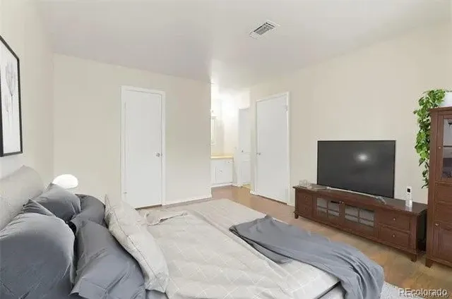 a bedroom with a bed and a flat screen tv