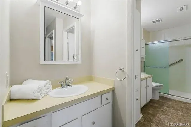 a bathroom with a granite countertop sink toilet and shower