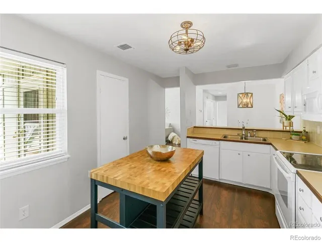 a kitchen with a sink a stove and wooden floor