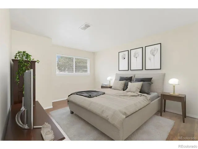 a bedroom with a bed a mirror and dresser