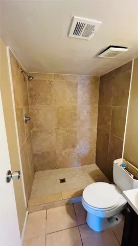 a bathroom with a toilet and a shower