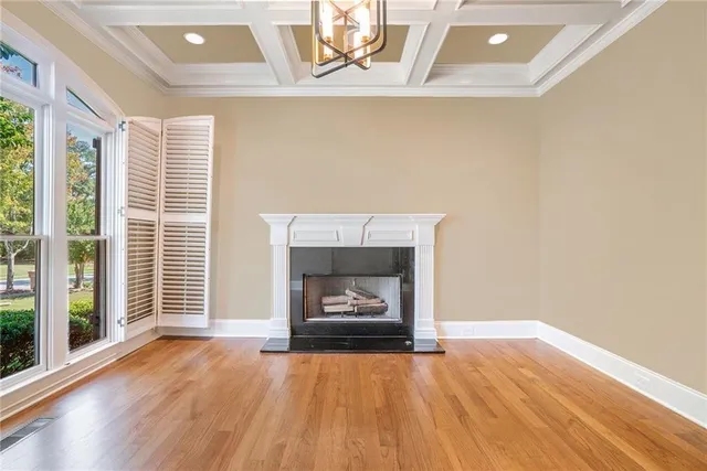 a view of an empty room with wooden floor and stairs