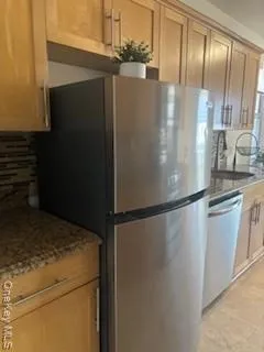 a view of a refrigerator in kitchen and stainless steel appliances wooden floor