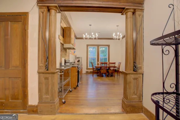 a view of a hallway with wooden floor and furniture