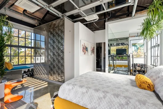 a bedroom with furniture and a large window