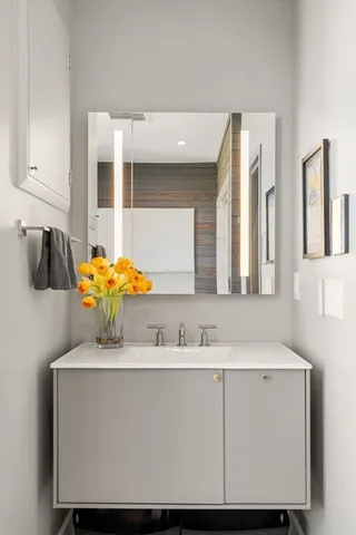 a bathroom with a sink vanity and mirror