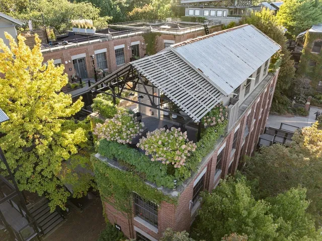 an aerial view of a house with a yard and wooden fence