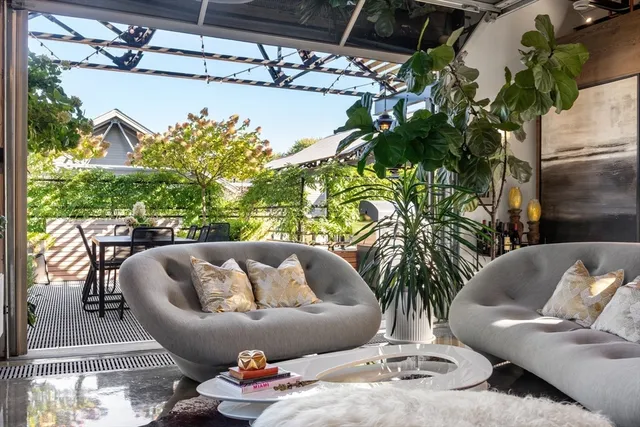a roof deck with couch and potted plants