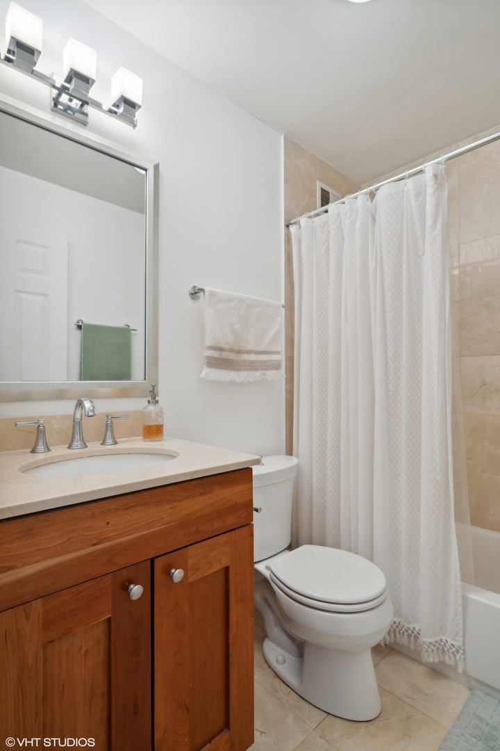 450 West Briar Place, Unit 7B Chicago, IL 60657 - Photo 13 of 15 a bathroom with a toilet a sink and a mirror