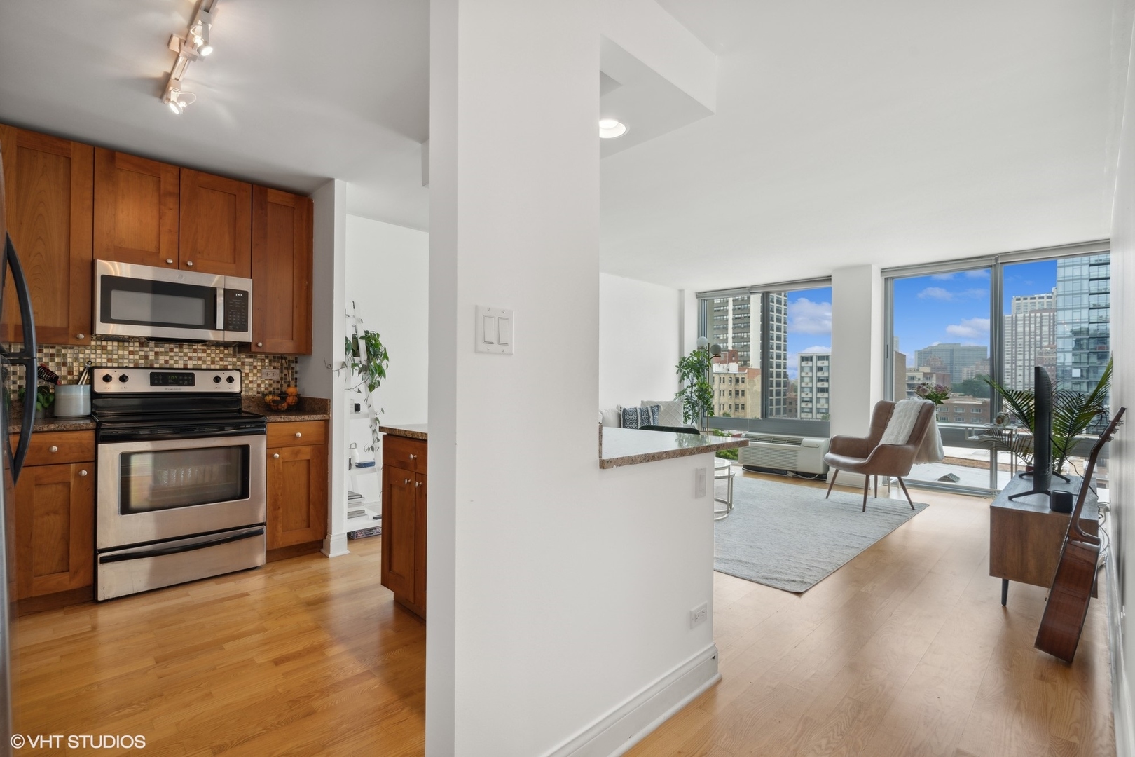 450 West Briar Place, Unit 7B Chicago, IL 60657 - Photo 2 of 15 a kitchen with stainless steel appliances a stove a sink a microwave a dining table and chairs