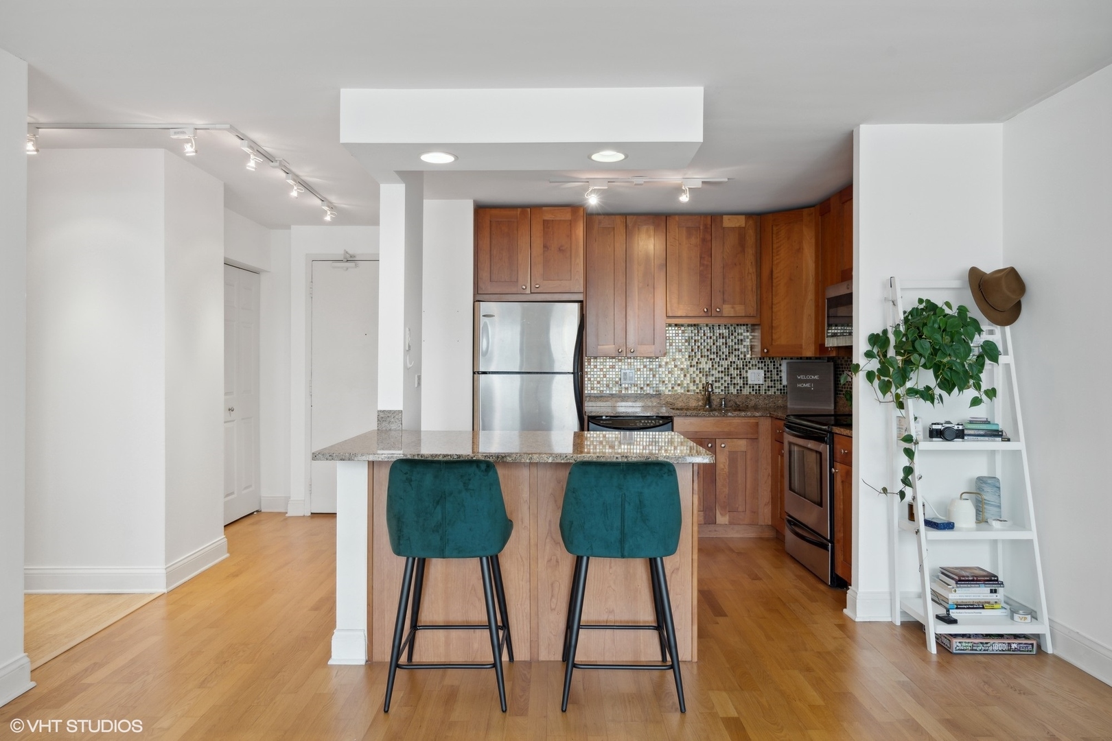 450 West Briar Place, Unit 7B Chicago, IL 60657 - Photo 7 of 15 a kitchen with stainless steel appliances kitchen island granite countertop a table and chairs in it