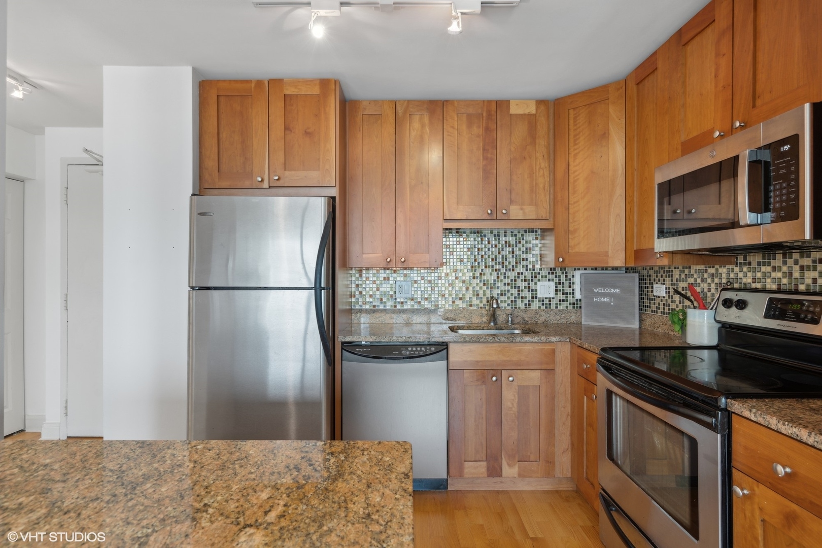 450 West Briar Place, Unit 7B Chicago, IL 60657 - Photo 9 of 15 a kitchen with stainless steel appliances granite countertop a refrigerator stove and sink