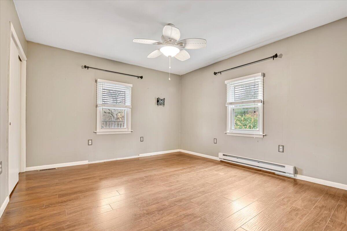 5039 Running Valley Road Stroudsburg, PA 18360 - Photo 23 of 65 an empty room with wooden floor chandelier fan and windows