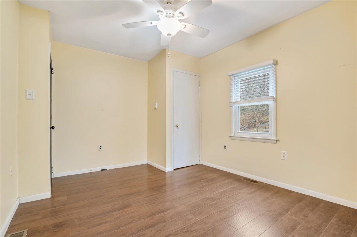 5039 Running Valley Road Stroudsburg, PA 18360 - Photo 26 of 65 an empty room with wooden floor chandelier fan and windows