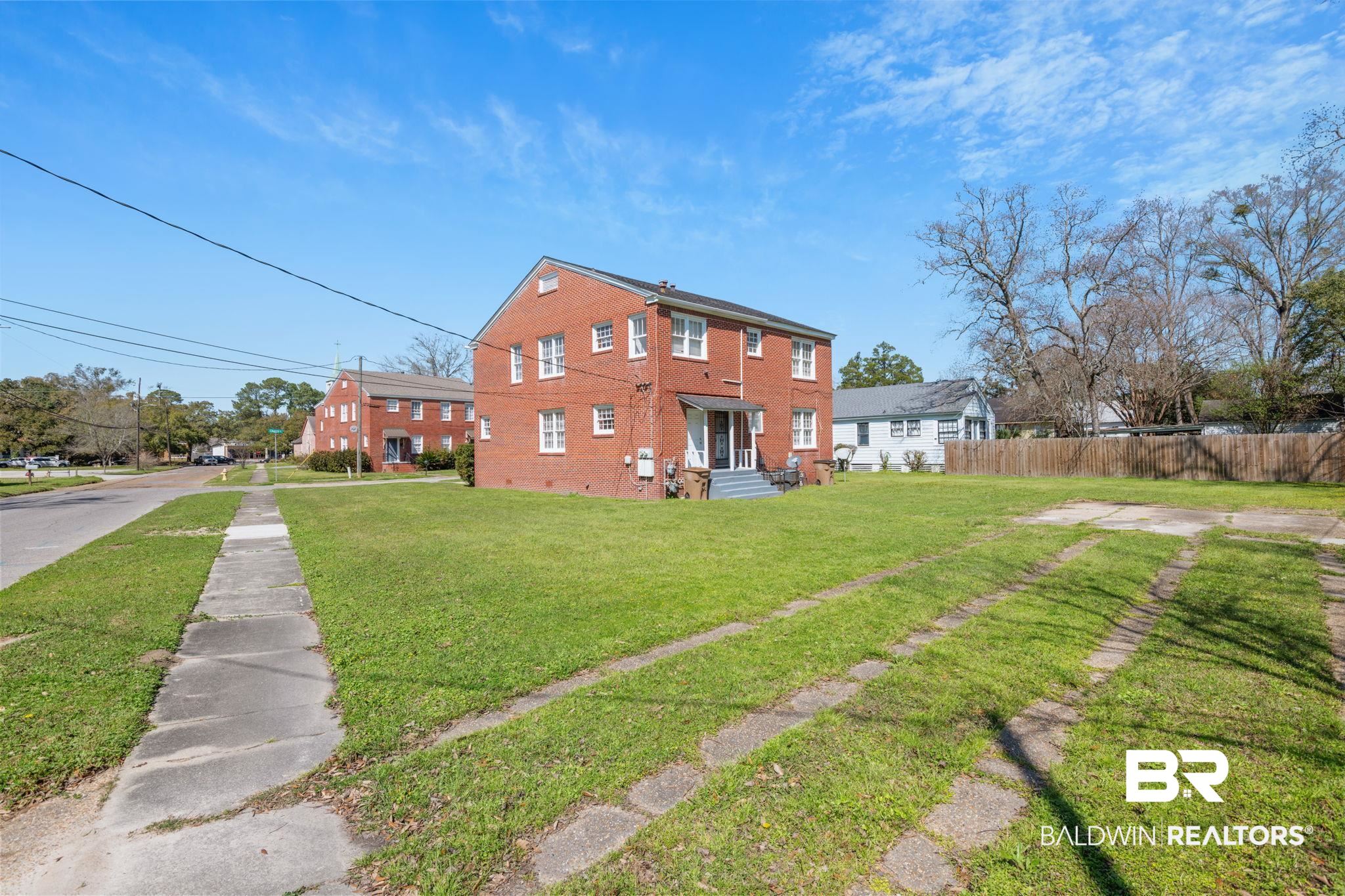 1707 Church Street Mobile, AL 36604 - Photo 3 of 43 Rear view of house with fence, brick siding, and a lawn