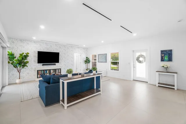 a large white kitchen with a large window and stainless steel appliances