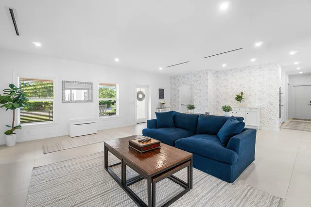 a large white kitchen with a large window a counter space a sink and stainless steel appliances