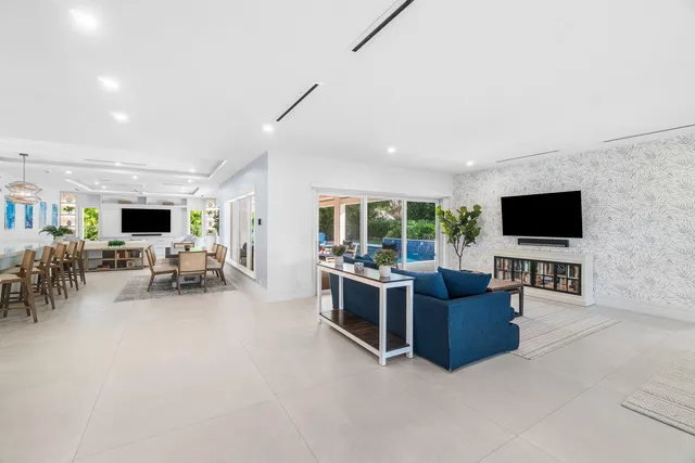 a kitchen with a dining table a chandelier and wooden cabinets