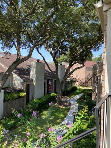 a front view of a house with a yard and potted plants