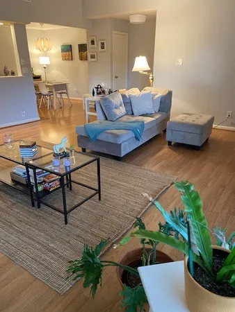 a living room with furniture and a wooden floor