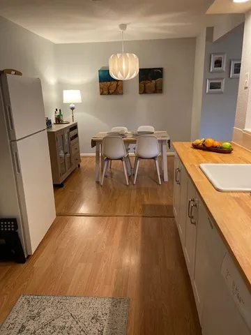 a kitchen with stainless steel appliances granite countertop a sink a stove a refrigerator a microwave oven with a dining table and chairs