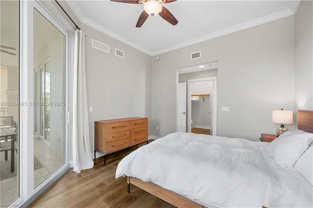 a bedroom with a bed and a dresser with wooden floor