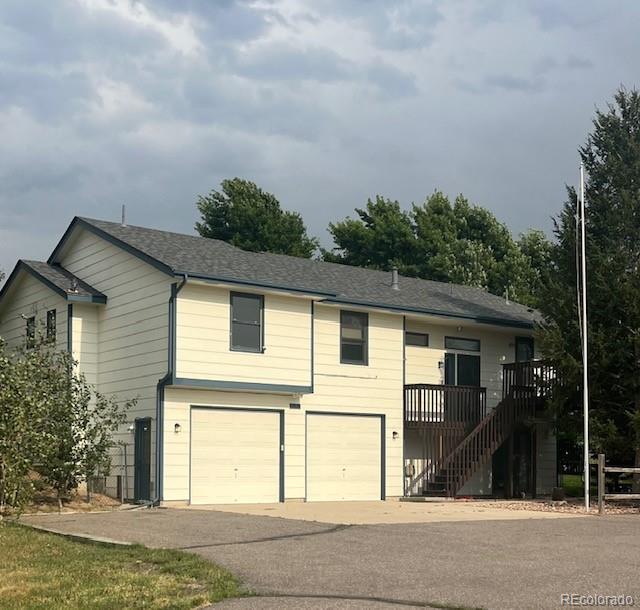 a view of a white house with large windows and a small yard