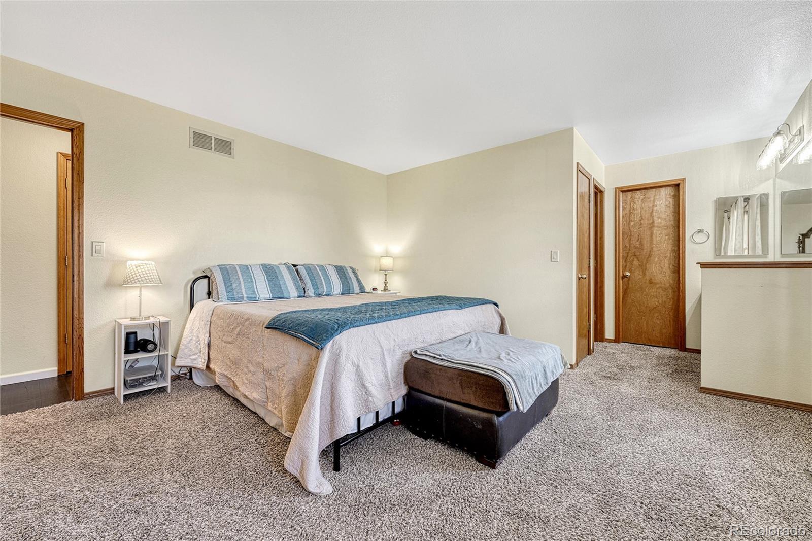 2460 Eileen Way Parker, CO 80138 - Photo 16 of 47 a spacious bedroom with a bed and a refrigerator