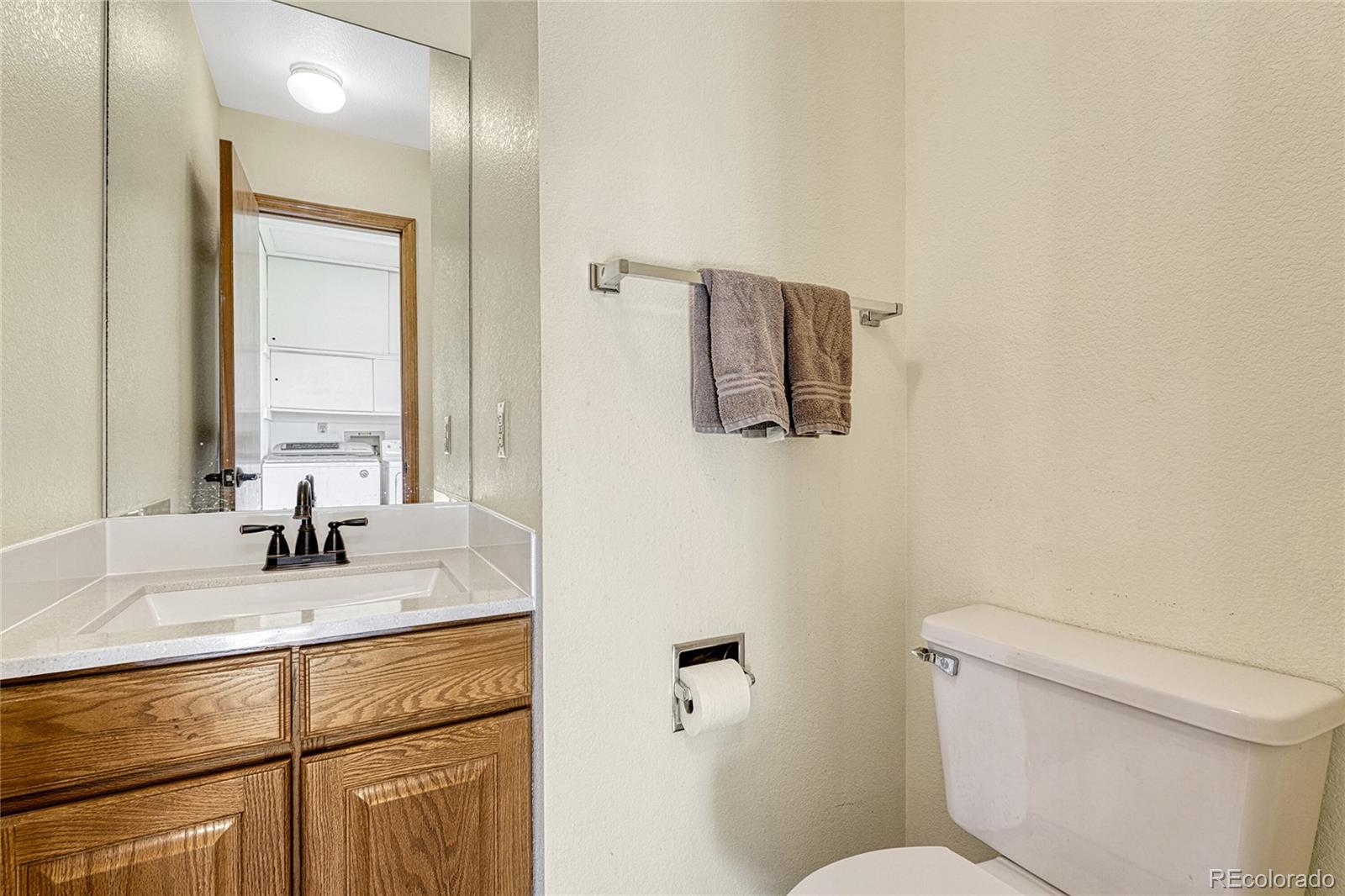 2460 Eileen Way Parker, CO 80138 - Photo 19 of 47 a bathroom with a toilet sink and mirror
