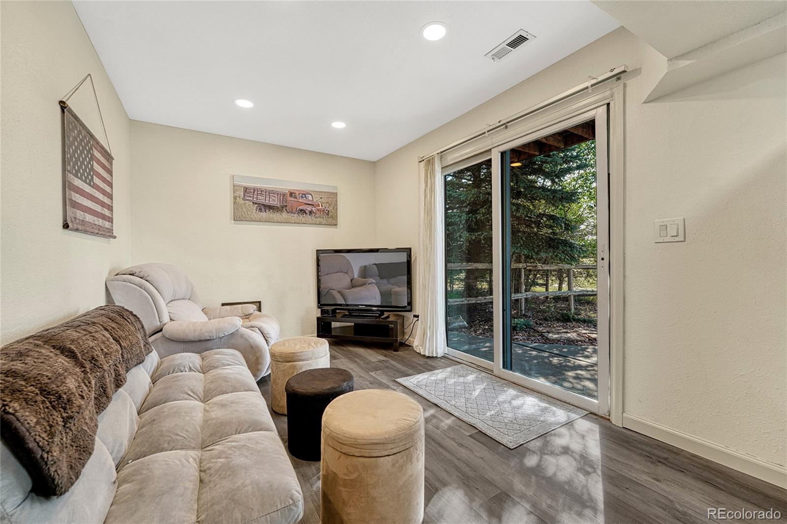 2460 Eileen Way Parker, CO 80138 - Photo 23 of 47 a living room with furniture a large window and a flat screen tv
