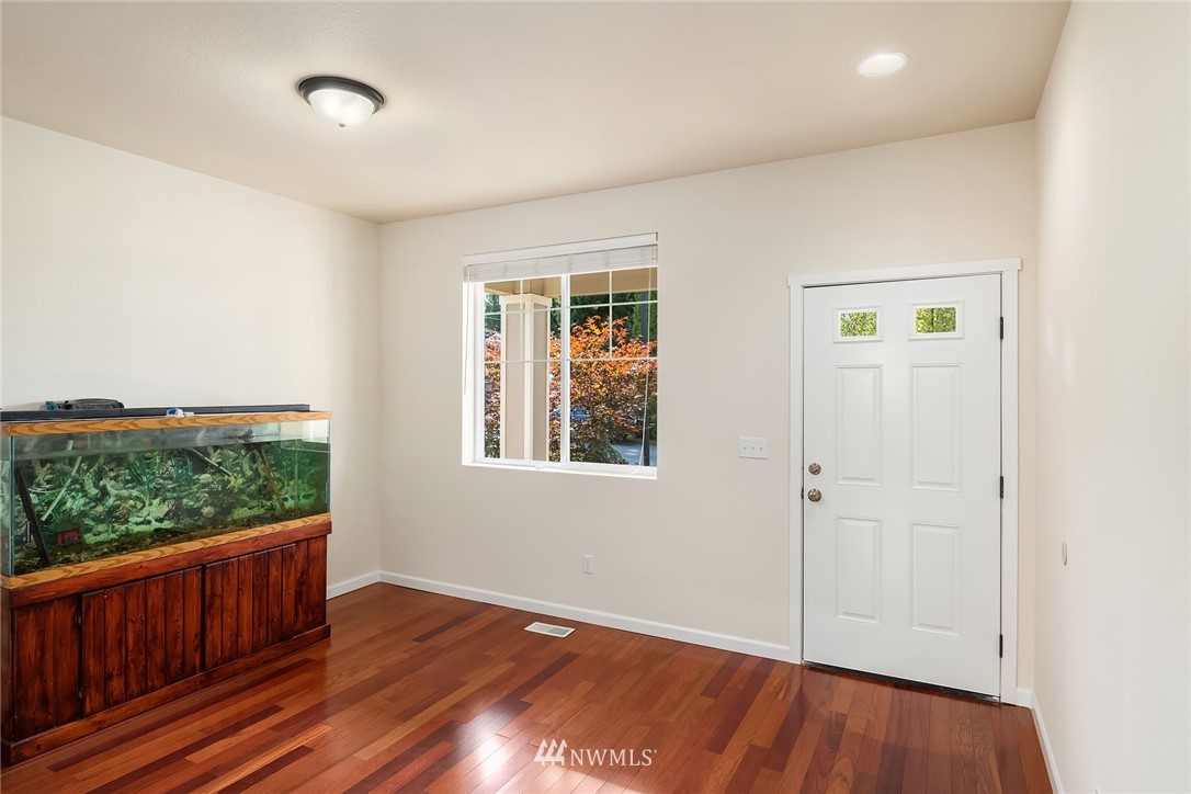 4532 Northeast 10th Street Renton, WA 98059 - Photo 4 of 24 an empty room with wooden floor and windows