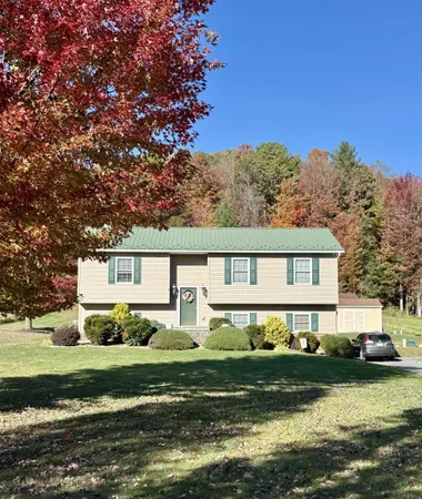 a front view of a house with a garden and lake