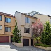 a front view of a house with a garden and lake view